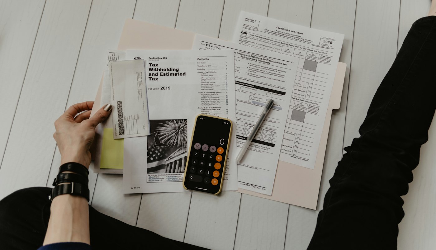 A desk with a calculator and planning worksheets used during a financial planning engagement.